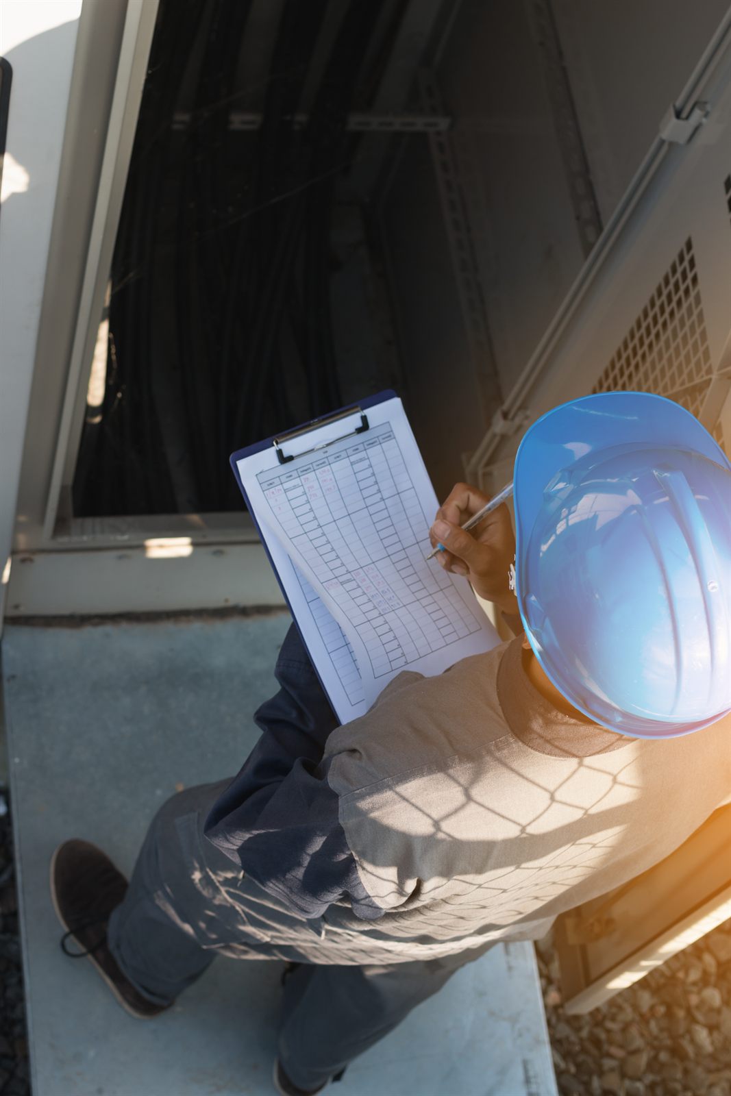 Site technician inspecting equipment with a checklist